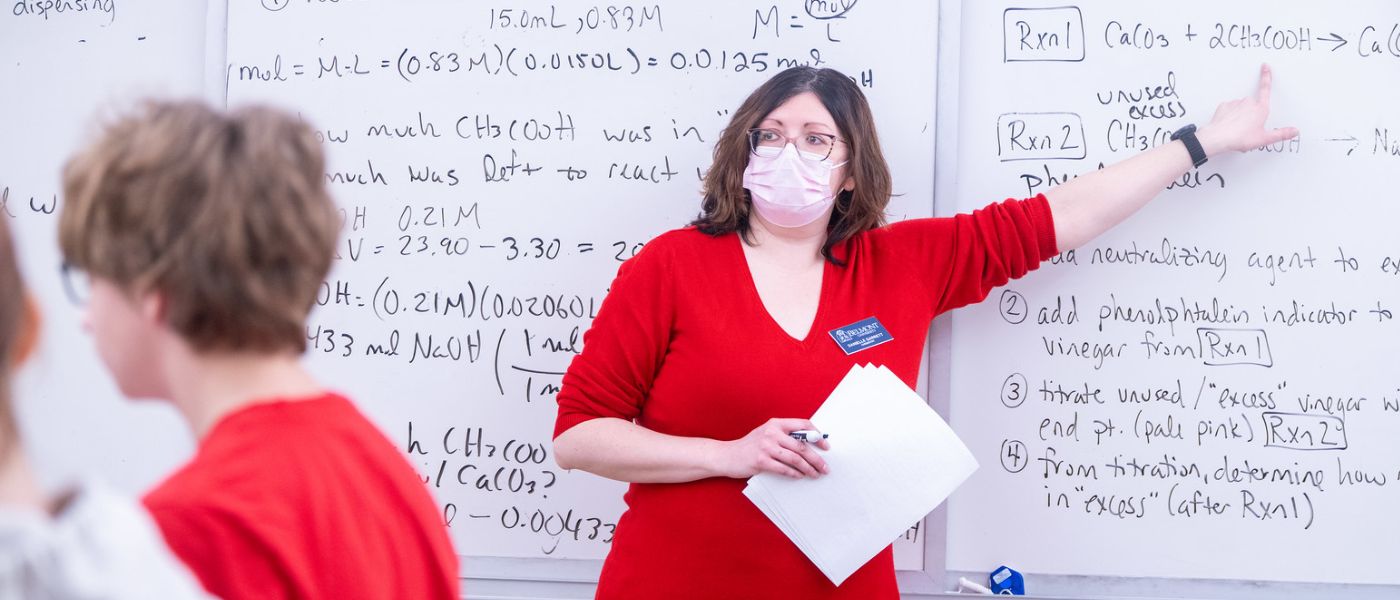 Dr. Danielle Garrett lectures in front of a whiteboard