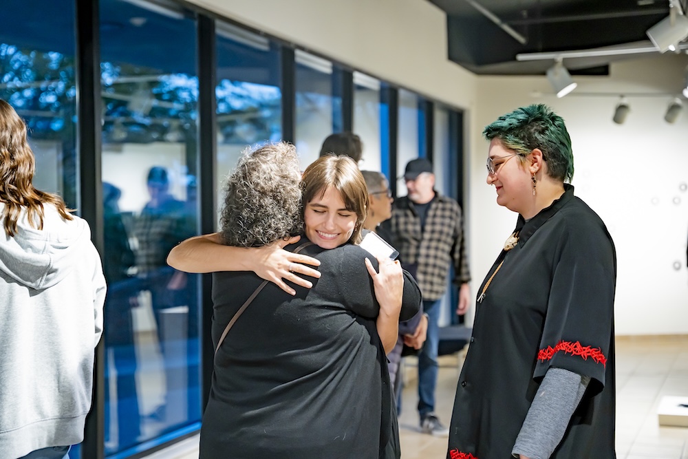 Nichols hugging someone who attended the gallery reception