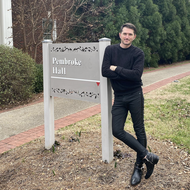Adam posing with Pembroke Hall sign