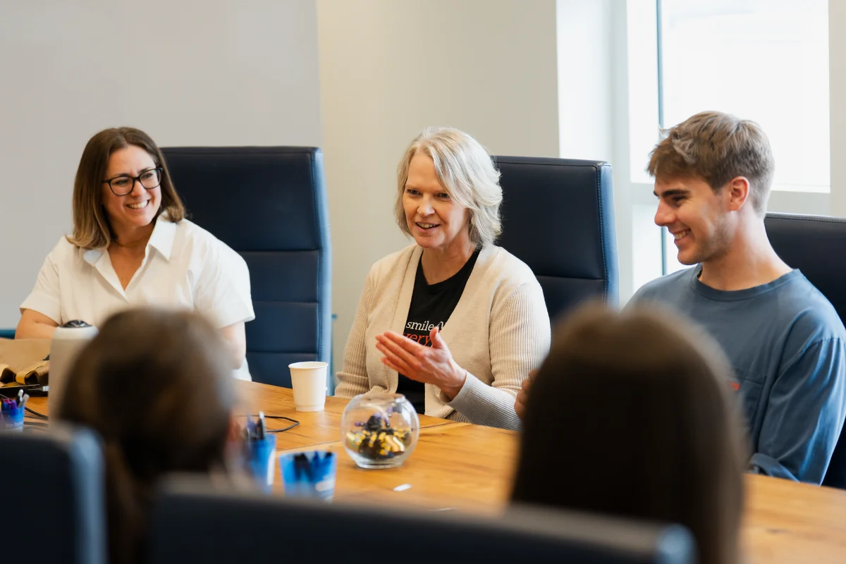people sitting at a table talking and smiling