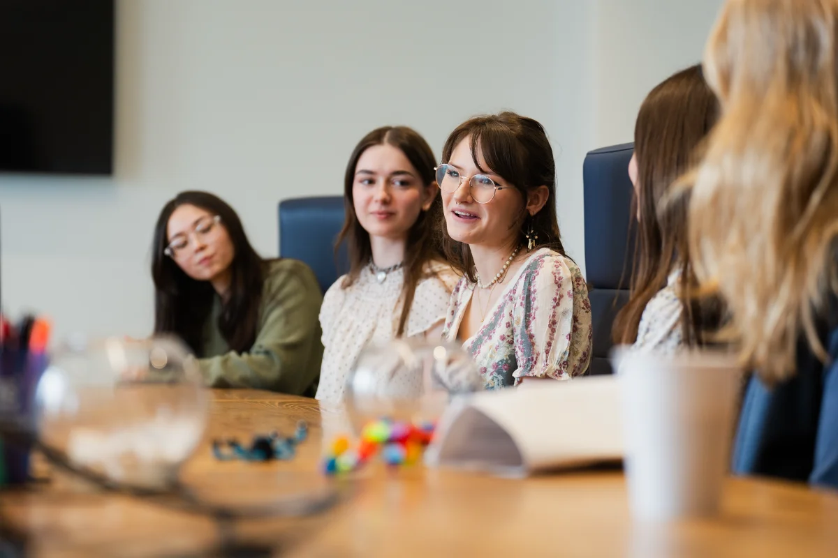 people sitting at a table listening and smiling
