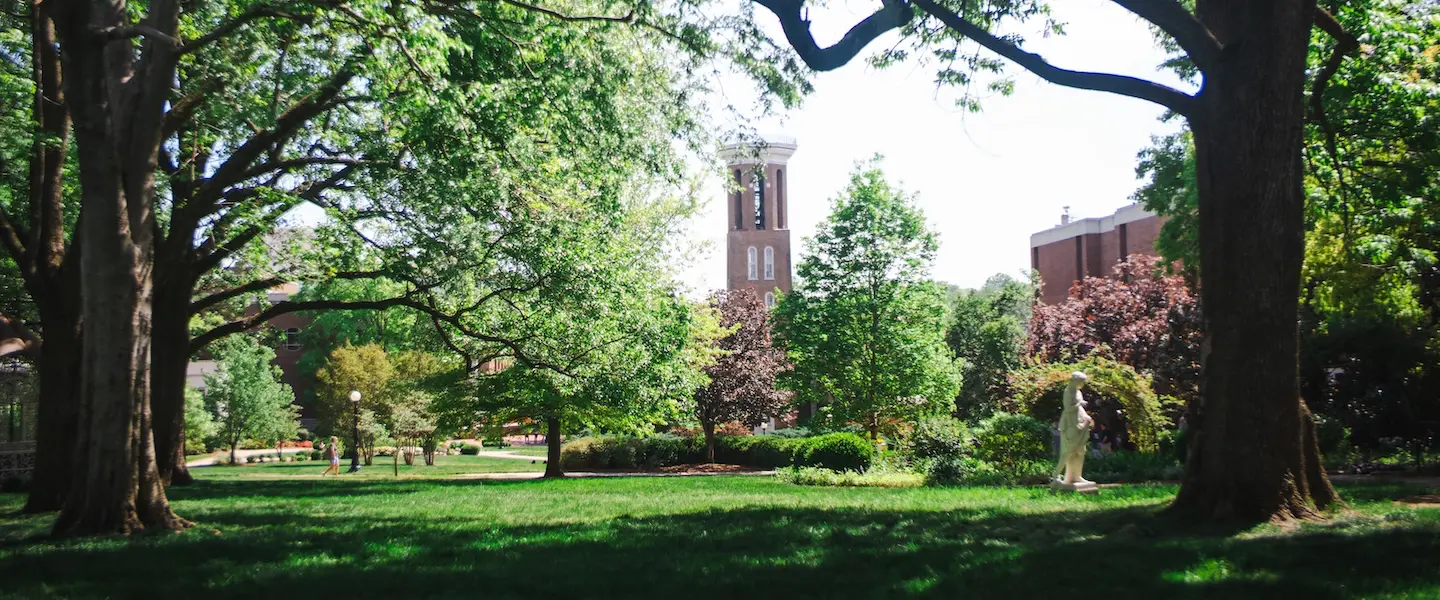 Campus lawn with bell tower in background