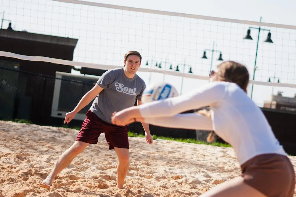Two people playing sand volleyball
