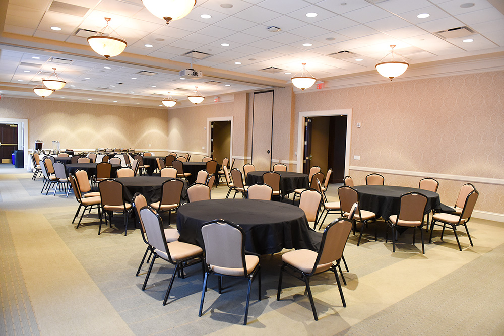 Frist Lecture Hall set up with round tables and chairs.