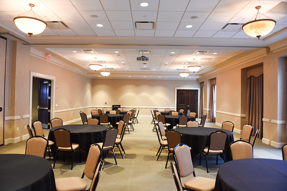 Frist Lecture Hall set up with round tables and chairs.