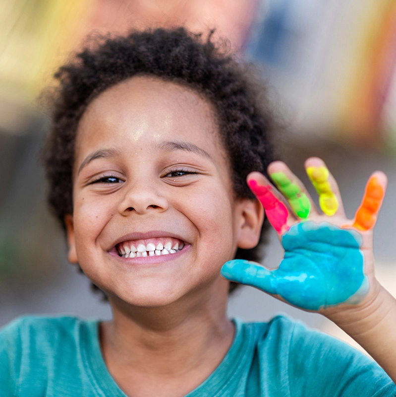 Student smiling with paint on hand