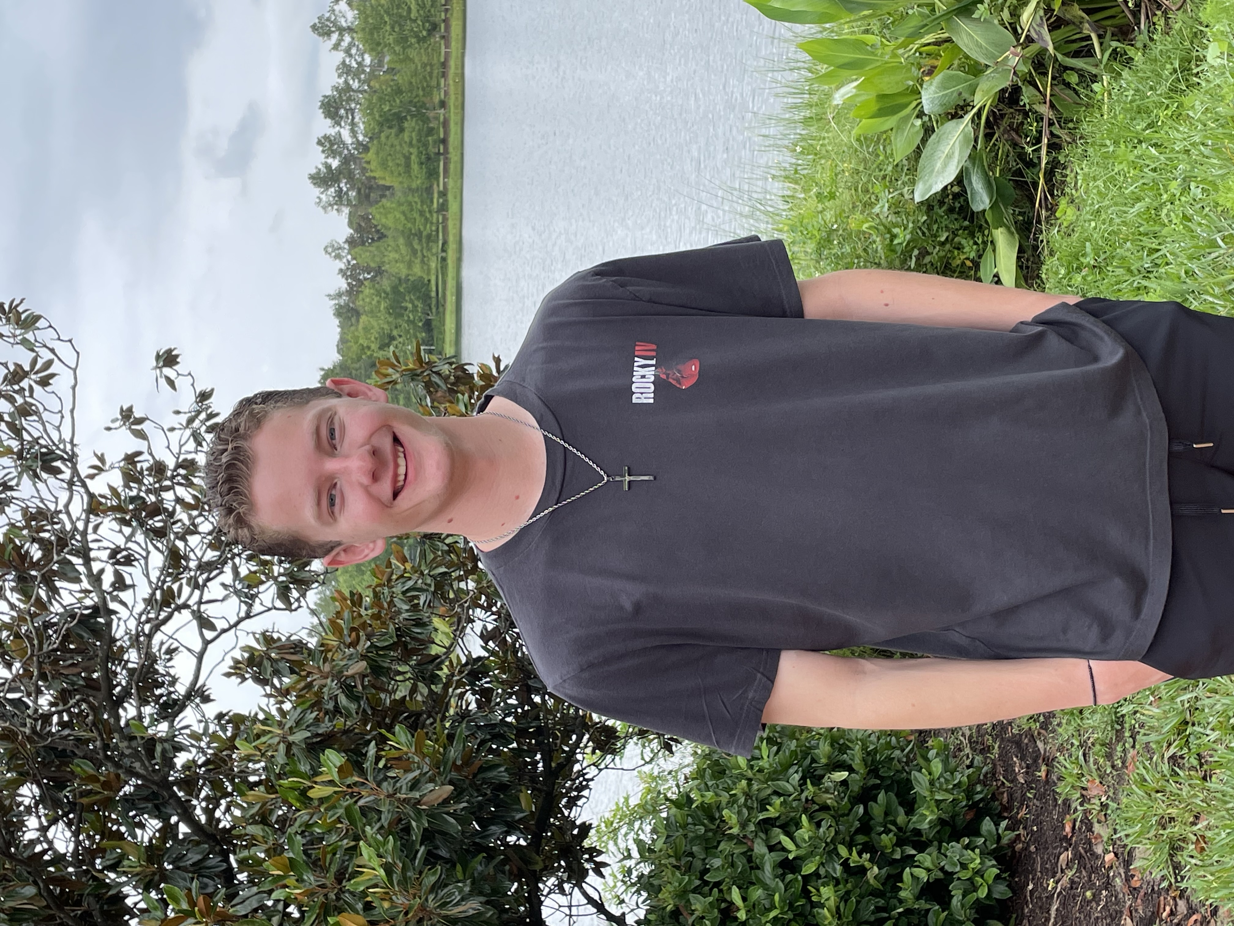 Brennan smiling in front of natural greenery