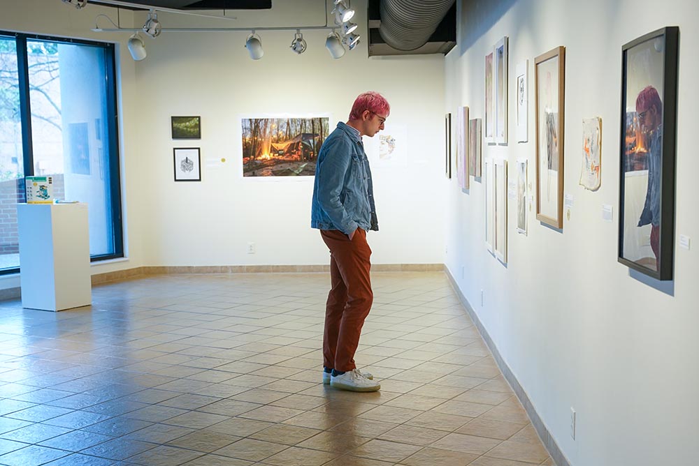 male in gallery looking at art