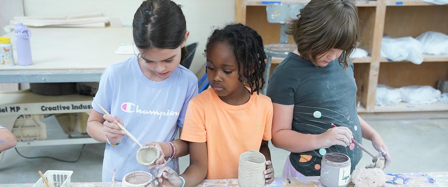Young girls painting pottery in pottery studio