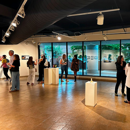 people stand in an art gallery viewing art