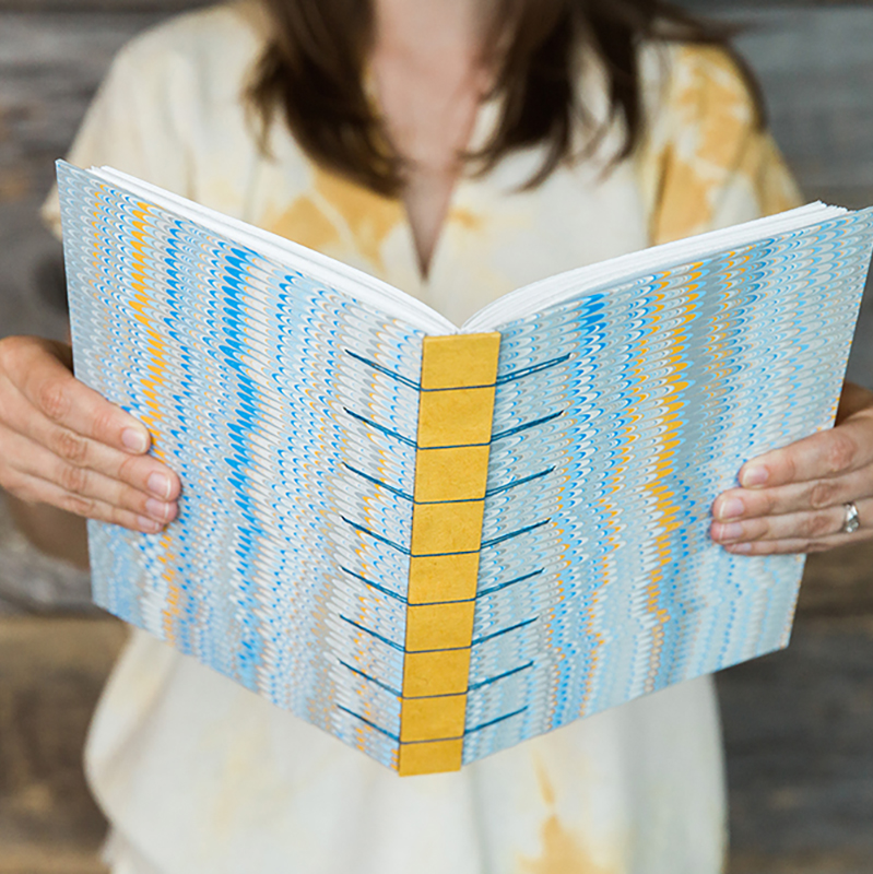 image of hands holding handbound book 