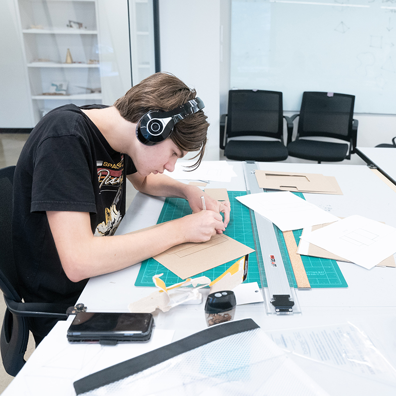 Student building a 3D model out of cardboard shapes